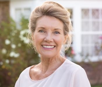 woman smiling with beautiful teeth after tooth replacement and dentures