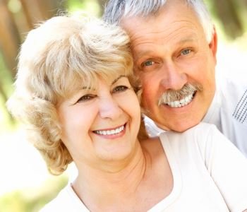 man and woman smiling with beautiful teeth after dental implant from Dr. David Spilkia